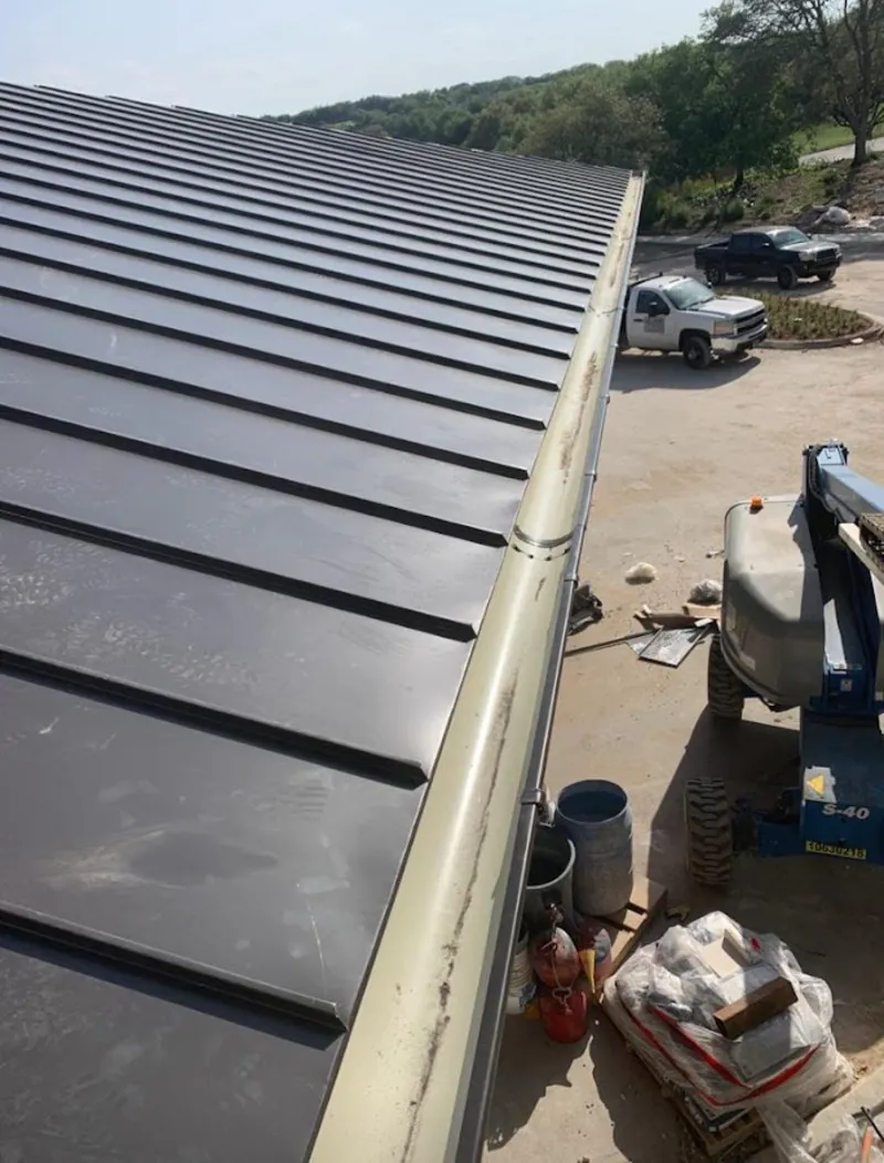 Standing seam panel and gutter detail on a metal roofing jobsite in Kingston